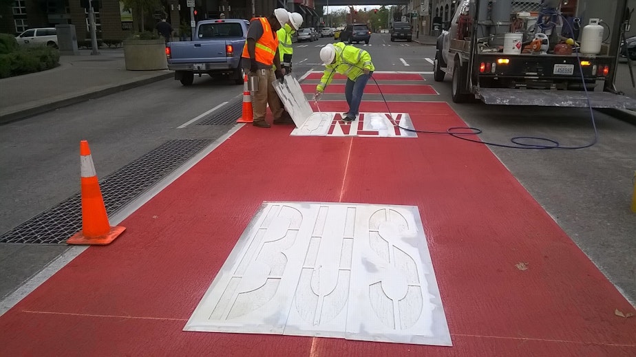 caption: An SDOT Crew puts finishing touches on a bus-only lane on Battery Street in Seattle's Belltown Neighborhood.