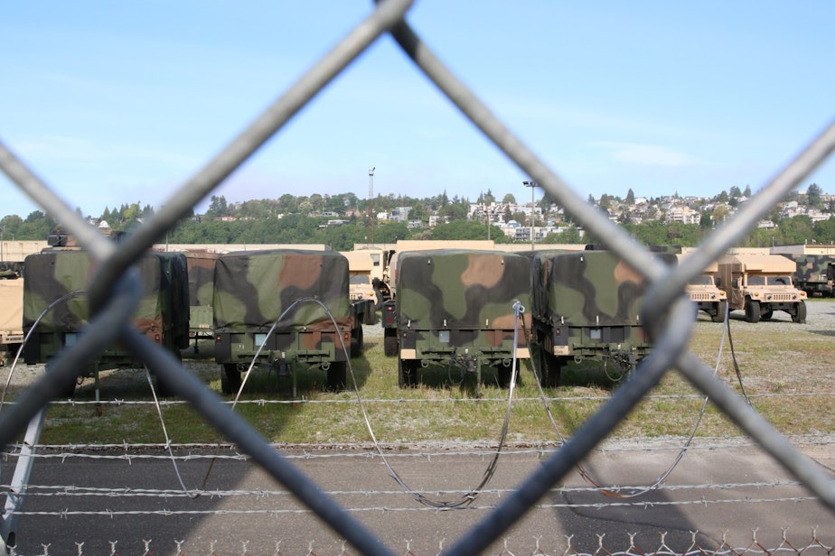 caption: The Washington National Guard's site in Seattle's Interbay neighborhood, seen through a fence at the edge of the Whole Foods parking lot.