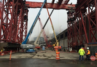 caption: The giant red crane will lift Bertha's cutter head to the surface for disassembly