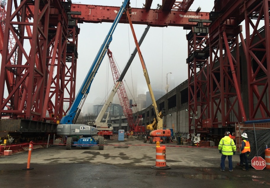 caption: The giant red crane will lift Bertha's cutter head to the surface for disassembly