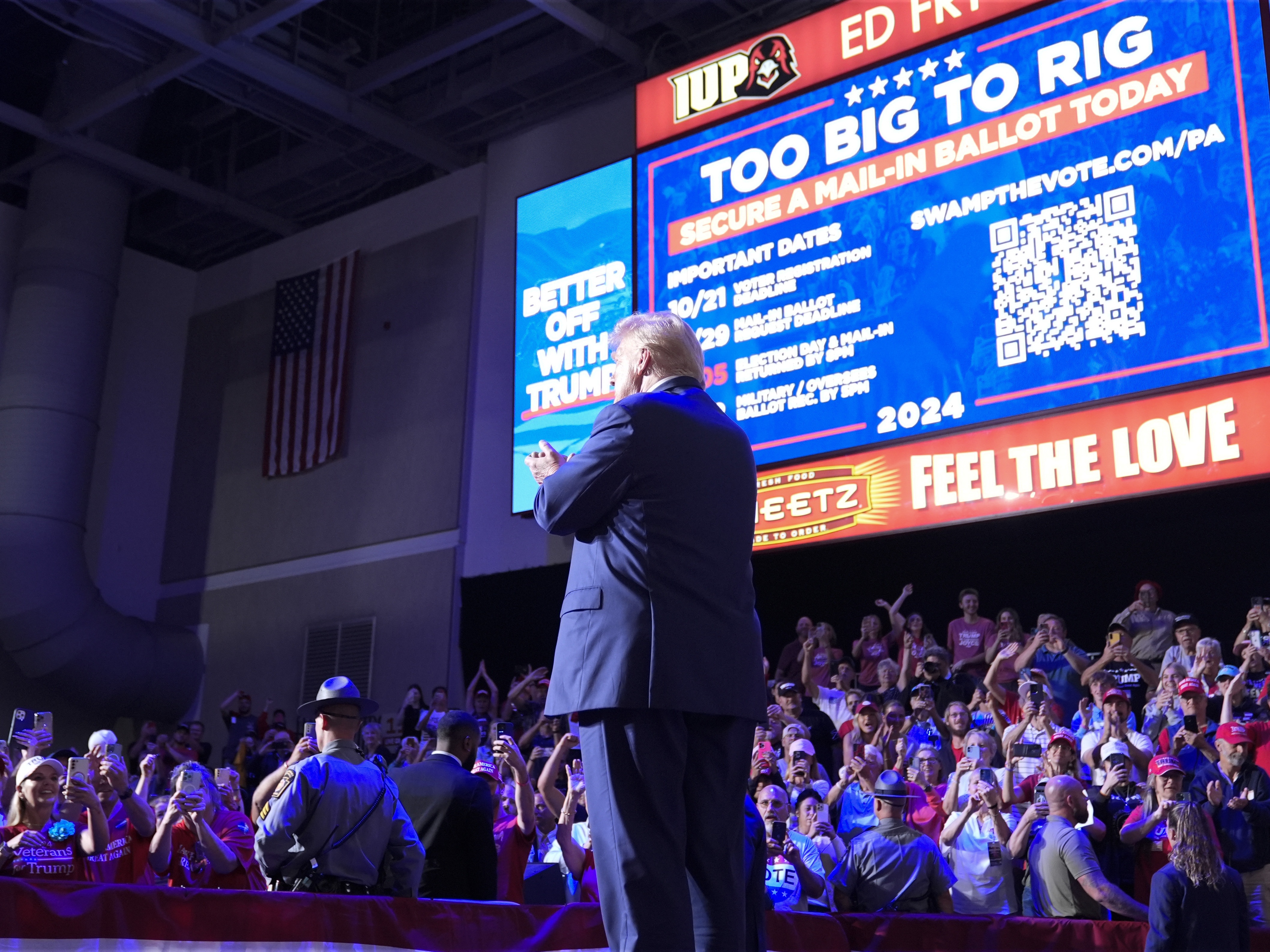 caption: Former President Donald Trump stands on stage after speaking at a campaign event in Indiana, Pa., on Sept. 23. Behind Trump, Republicans are urged to vote in numbers that are "too big to rig."