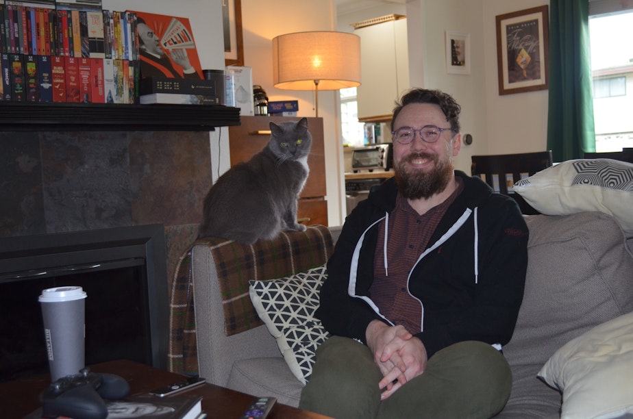 caption: Evan Pulgino lives with his cat Vigo in White Center. Within a week of the Supreme Court's Dobbs ruling ending the right to an abortion in the U.S., he scheduled a vasectomy.