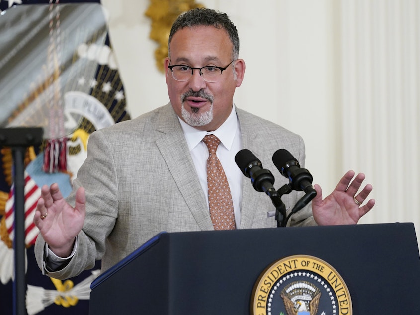 caption: Education Secretary Miguel Cardona speaks at the White House on April 27. The Biden administration proposed a dramatic rewrite of campus sexual assault rules on Thursday, moving to expand protections for LGBTQ students, bolster the rights of victims and widen colleges' responsibilities in addressing sexual misconduct.