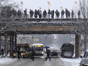 caption: Commuters wait for a train as snow falls in Chicago. With a polar vortex hitting the Midwest, wind chills could dip to 55 degrees below zero in northern Illinois.
