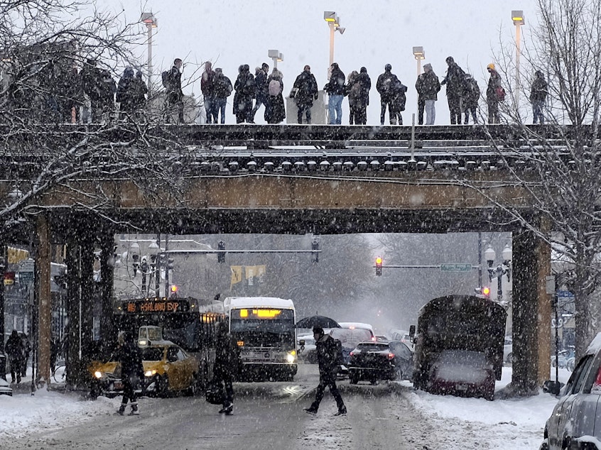 caption: Commuters wait for a train as snow falls in Chicago. With a polar vortex hitting the Midwest, wind chills could dip to 55 degrees below zero in northern Illinois.