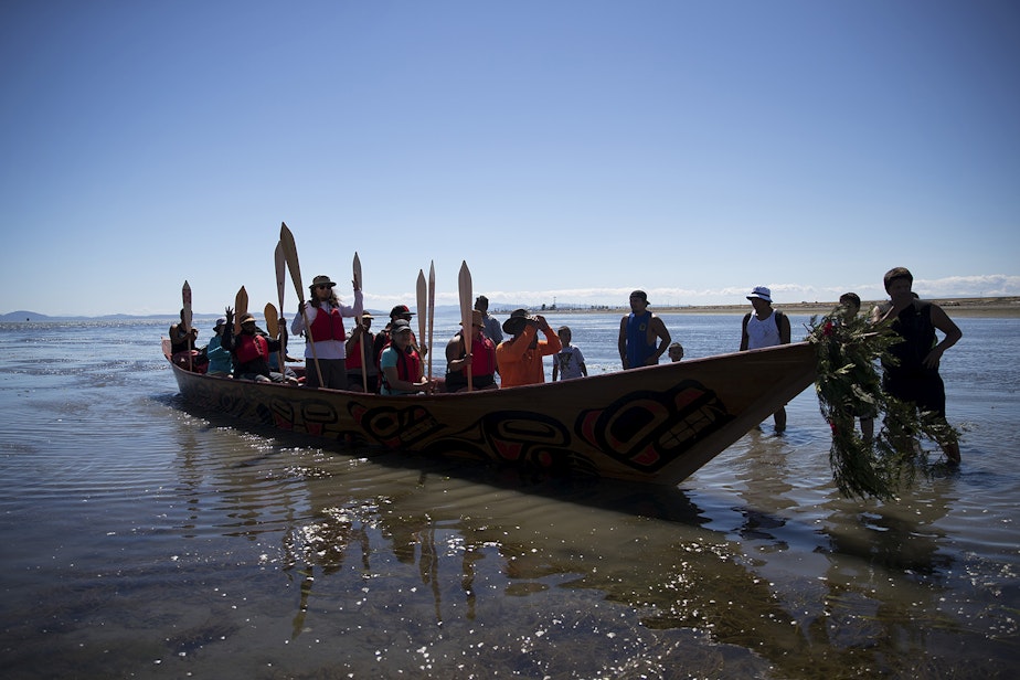 caption: Members of the 'Emma canoe' arrive on the shore of the Tsawwassen Indian Reserve after the first leg of their multi-day canoe journey on Thursday, July 27, 2017, in Tsawwassen, British Columbia.