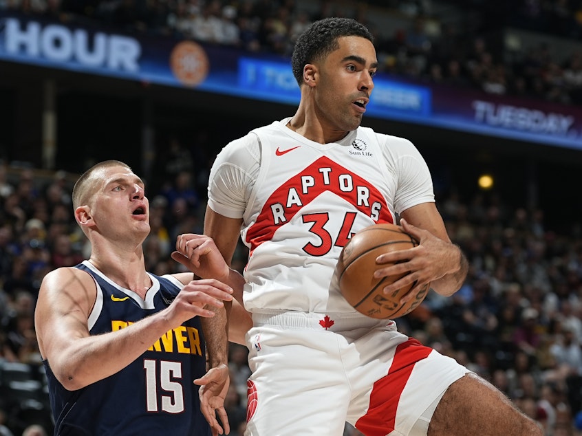 caption: Toronto Raptors center Jontay Porter (right) pulls in a rebound as Denver Nuggets center Nikola Jokic defends in an NBA game on March 11 in Denver. On Wednesday, the NBA banned Porter after a league probe found he disclosed confidential information to sports bettors and bet on games.