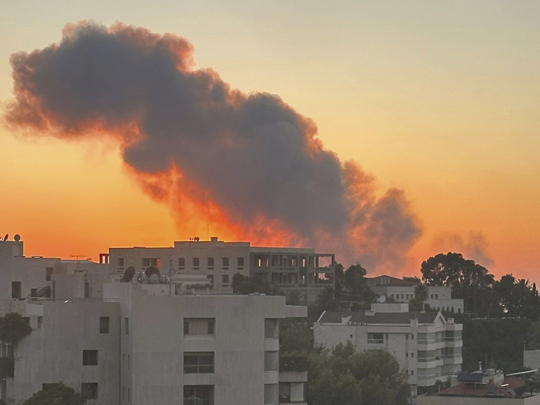 caption: Smoke rises from Israeli airstrikes in Beirut, seen from Baabda, Friday.