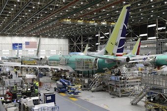caption: FILE - In this March 27, 2019, file photo people work on the Boeing 737 MAX 8 assembly line during a brief media tour in Boeing's 737 assembly facility in Renton, Washington