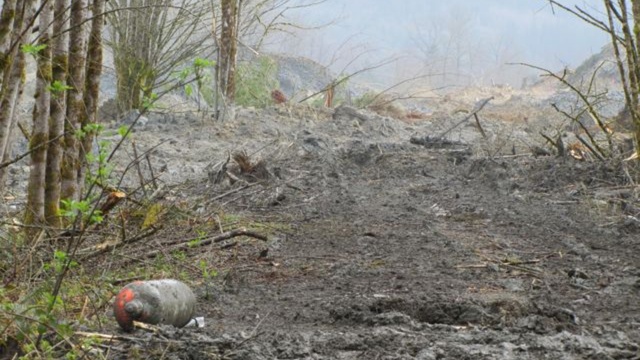 caption: Propane tanks floated to the surface of the massive landslide debris field that engulfed 42 homes near Oso, Wash.