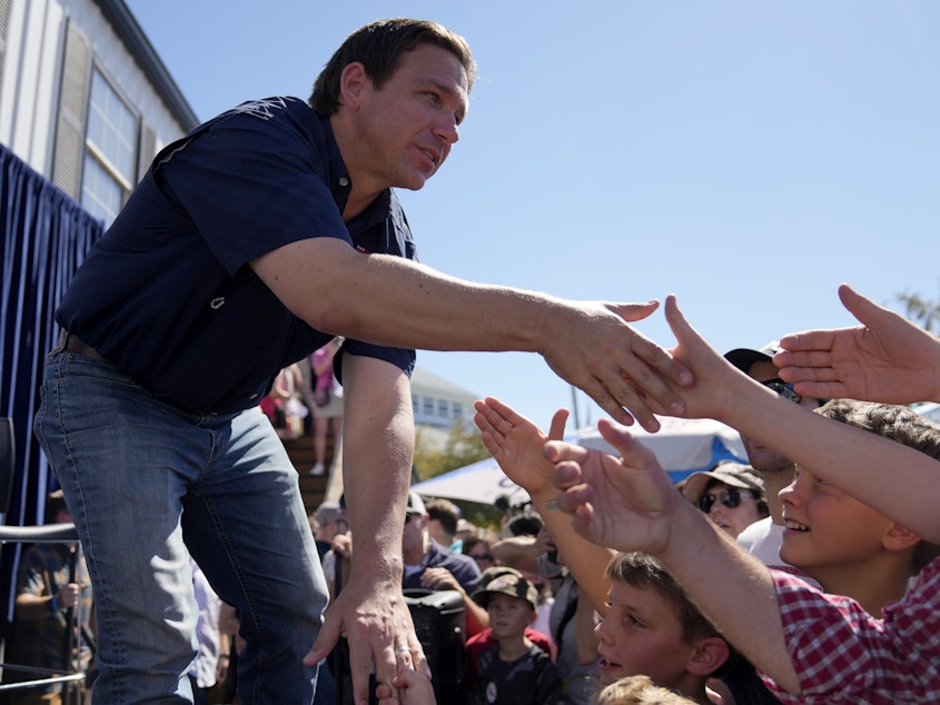 caption: Republican presidential candidate Florida Gov. Ron DeSantis shakes hands with fairgoers at the Iowa State Fair, August 12 in Des Moines, Iowa.