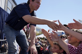 caption: Republican presidential candidate Florida Gov. Ron DeSantis shakes hands with fairgoers at the Iowa State Fair, August 12 in Des Moines, Iowa.