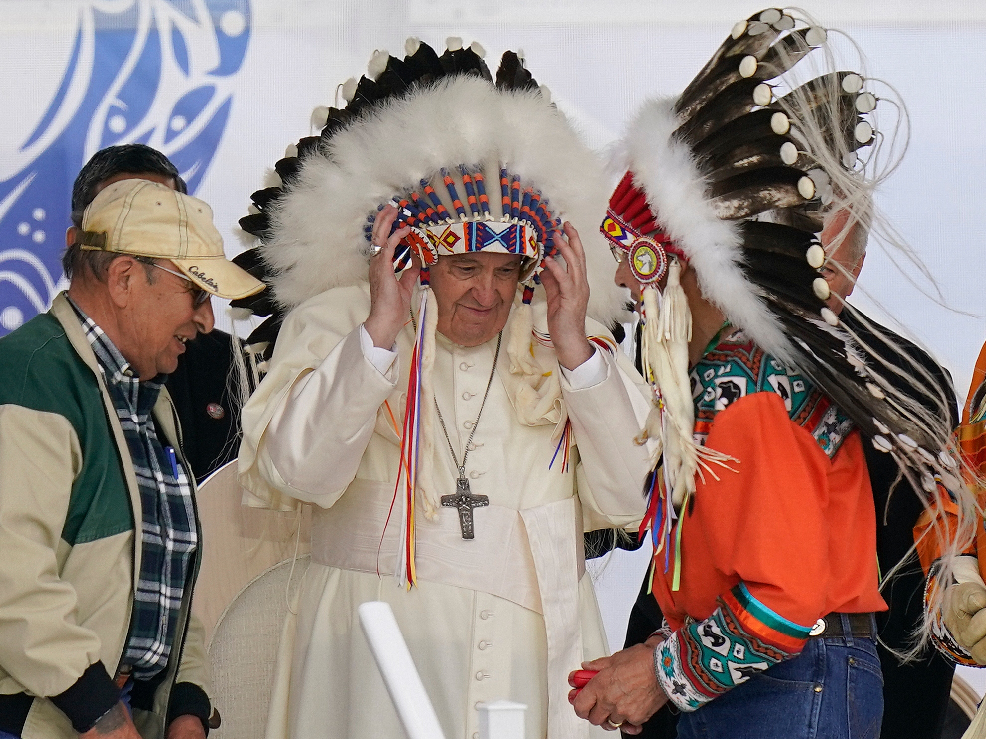 caption: Pope Francis dons a headdress during a visit with Indigenous peoples at the former Ermineskin Residential School in Maskwacis, Alberta, on July 25, 2022. The Vatican on Saturday returned 62 artifacts to Indigenous peoples from Canada.