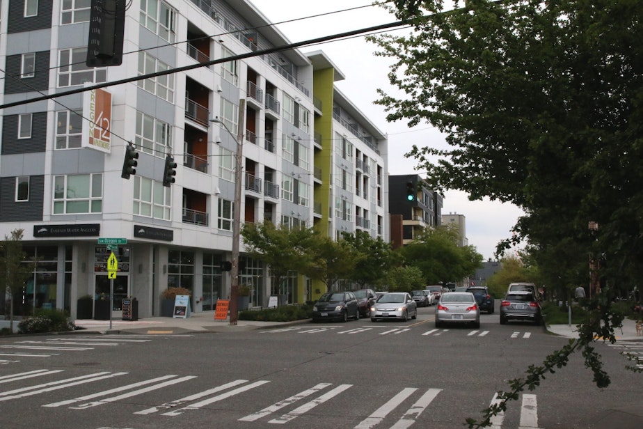 caption: An new apartment building across the street from one of the West Seattle Junction free parking lots.