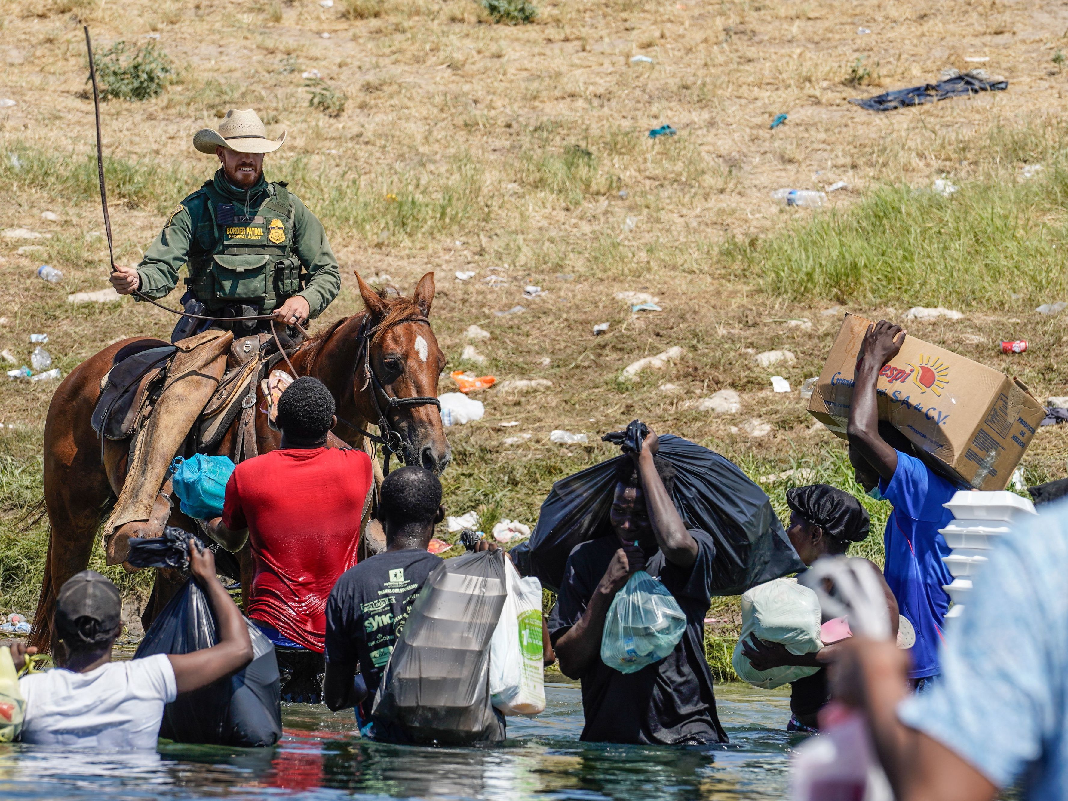 caption: A United States Border Patrol agent on horseback uses the reins as he tries to stop Haitian migrants from entering an encampment on the banks of the Rio Grande near the Acuna Del Rio International Bridge in Del Rio, Texas on September 19, 2021.