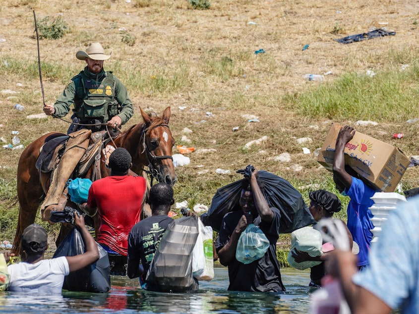caption: A United States Border Patrol agent on horseback uses the reins as he tries to stop Haitian migrants from entering an encampment on the banks of the Rio Grande near the Acuna Del Rio International Bridge in Del Rio, Texas on September 19, 2021.