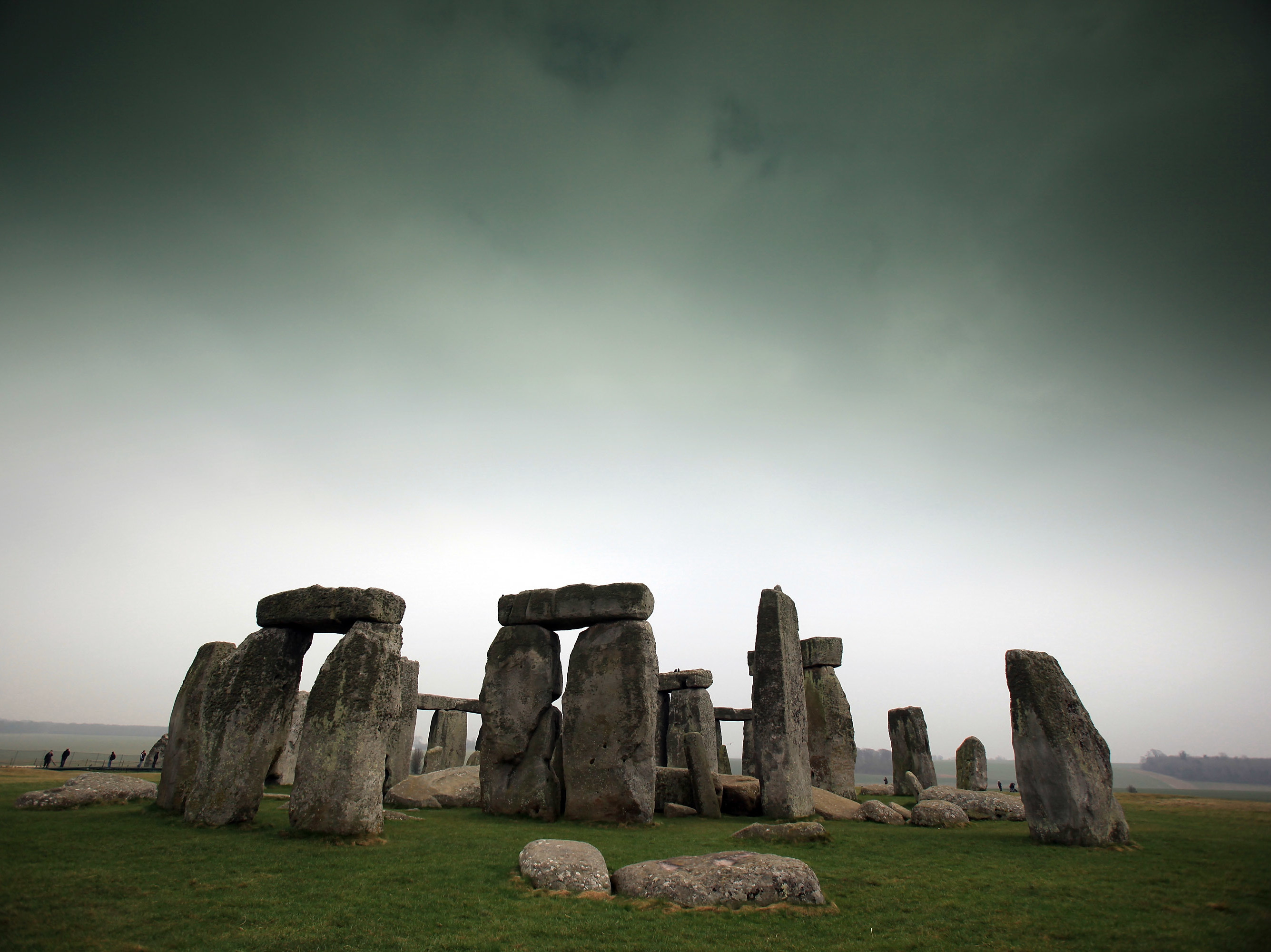 caption: Visitors and tourists walk around the ancient monument at Stonehenge in 2012 in Wiltshire, England.