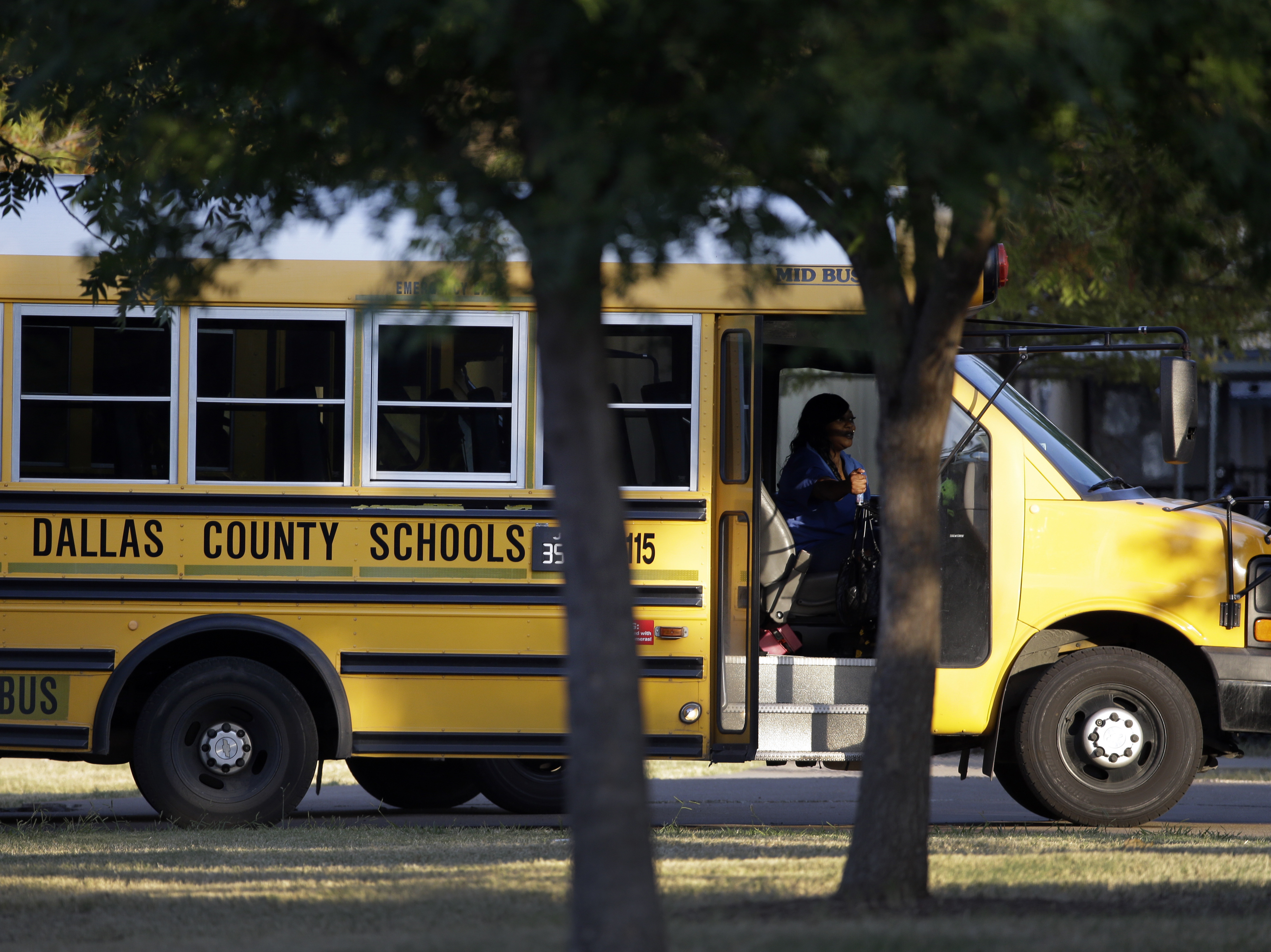 caption: A Dallas Independent School District bus departs L.L. Hotchkiss Elementary school after dropping off students, Thursday, Oct. 2, 2014, in Dallas.