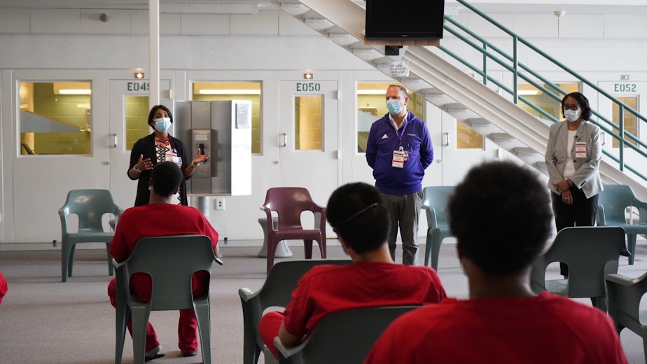 caption: Dr. Shireesha Dhanireddy, Dr. Santiago Neme and Dr. Bessie Young speak with inmates about the Covid vaccine at the Maleng Regional Justice Center on June 3, 2021. 