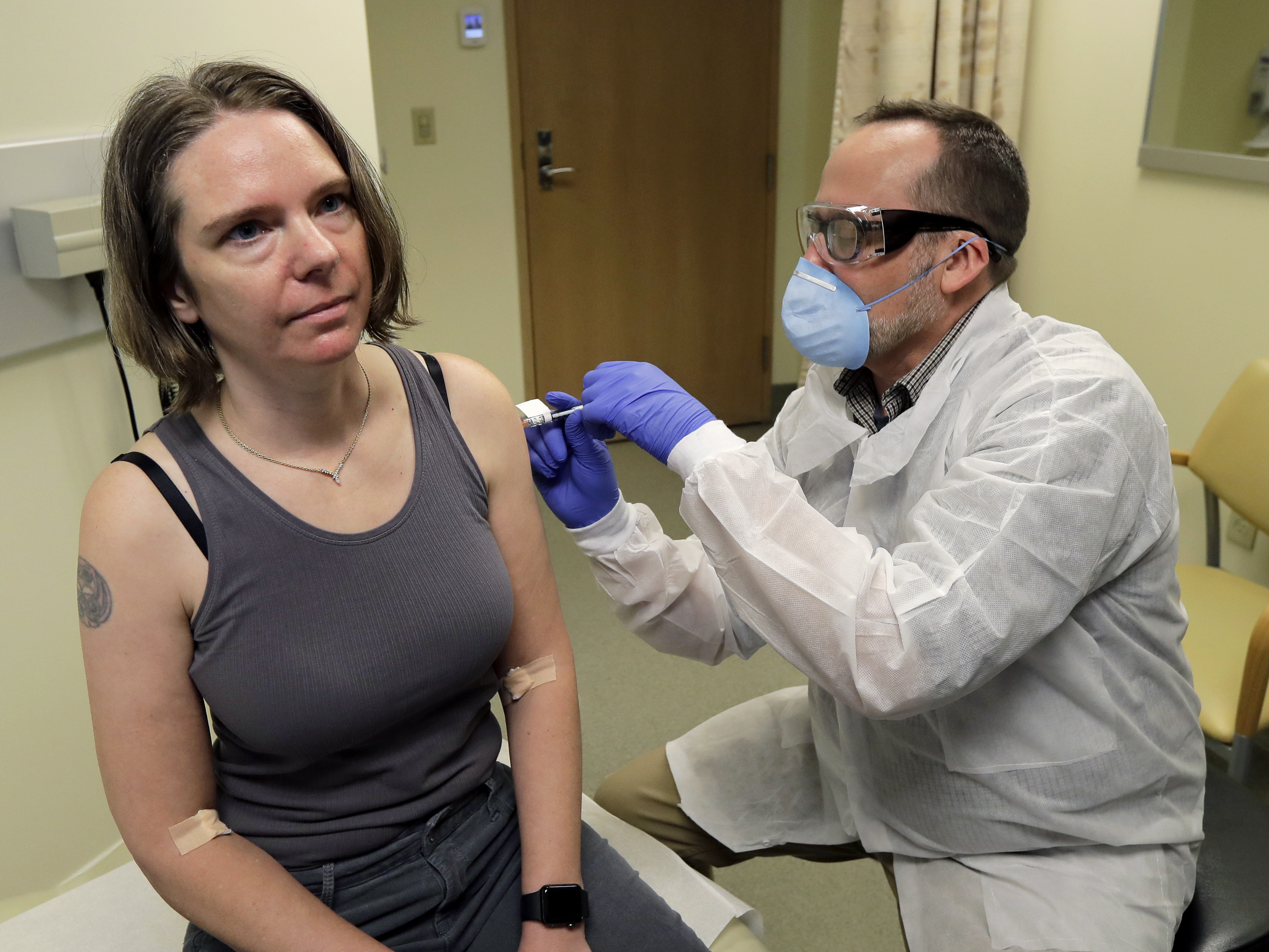 caption: A pharmacist gives Jennifer Haller a shot in the first-stage safety clinical trial of a potential vaccine for COVID-19 on March 16 at the Kaiser Permanente Washington Health Research Institute in Seattle. U.S. officials say they are already seeing efforts by foreign actors to steal information from U.S. firms working on a vaccine and treatments for the virus.