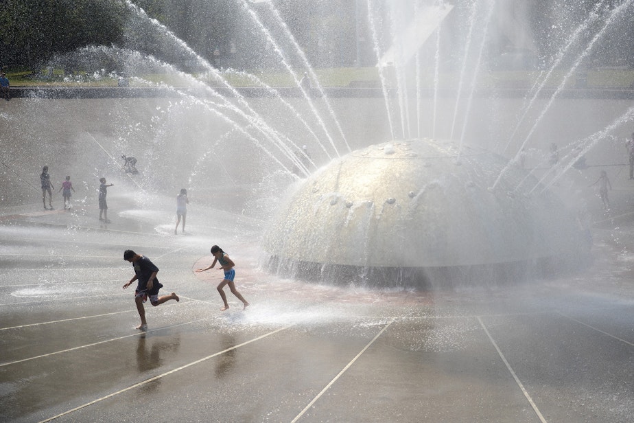 caption: Kids play at the Seattle Center's International Fountain on a hot day in July last summer.