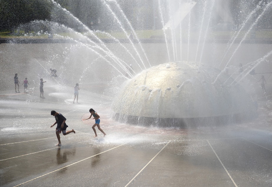 caption: Kids play at the Seattle Center's International Fountain on a hot day in July last summer.