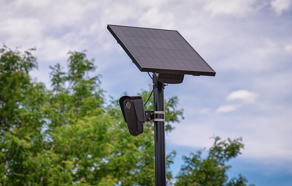 caption: A Flock Safety automated license plate reader (ALPR) camera outside a retail store in Aurora, Colorado, on June 27, 2024.