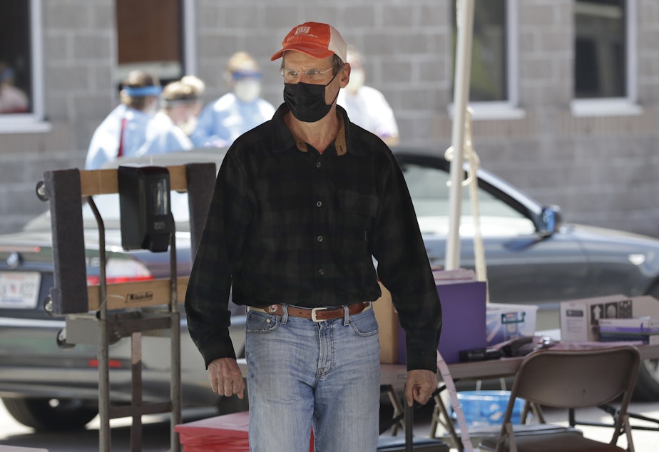 caption: Tennessee Gov. Bill Lee visits a drive-through COVID-19 testing location on April 18 in Franklin, Tenn.