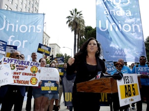 caption: Assemblywoman Lorena Gonzalez, D-San Diego, speaks at an August 28 rally in Sacramento, Calif., calling for passage of AB5 to limit when companies can label workers as independent contractors.