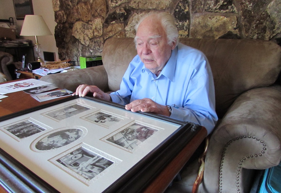 caption: Henry Chamberlain looks at mementos from World War II. He spent three and a half years as a prisoner of the Japanese.