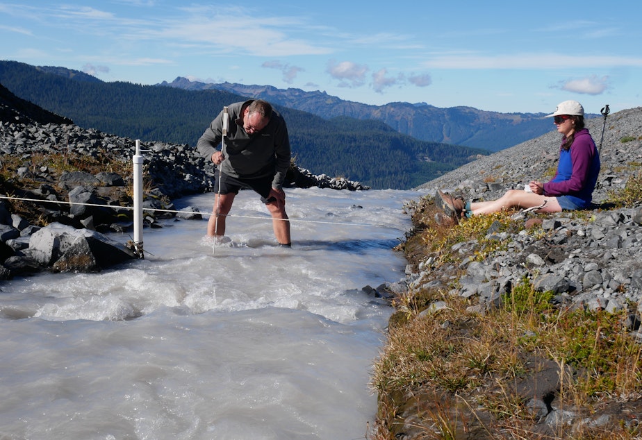 caption: Oliver Grah and Liza Kimberly measure the flow of glacier-fed Sholes Creek on Mount Baker