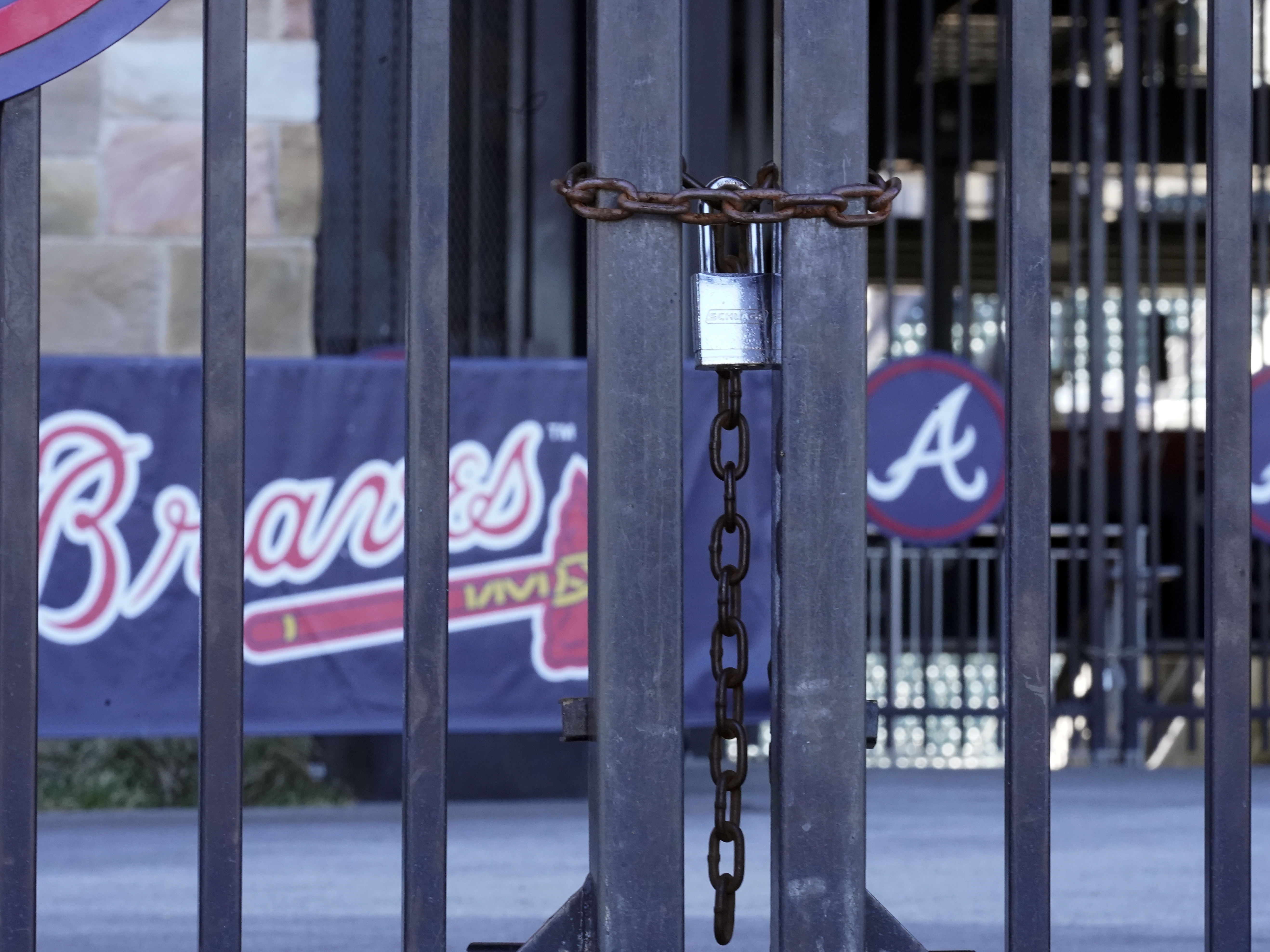 caption: Locked gates are shown at Truist Park home of the Atlanta Braves baseball team Wednesday, March 2, 2022, in Atlanta. Negotiators for locked-out players made their latest counteroffer to Major League Baseball on Wednesday.