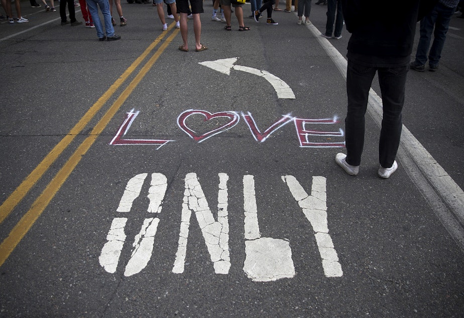 caption: 'Love' is painted on the ground at the intersection of 12th Avenue and East Pine Street, outside of the Seattle Police Department's East Precinct building, in the 'Capitol Hill Autonomous Zone', also known as CHAZ, on Wednesday, June 10, 2020, in Seattle.