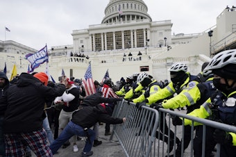 caption: Insurrectionists loyal to President Donald Trump try to break through a police barrier on Jan. 6, 2021, at the Capitol in Washington, D.C.