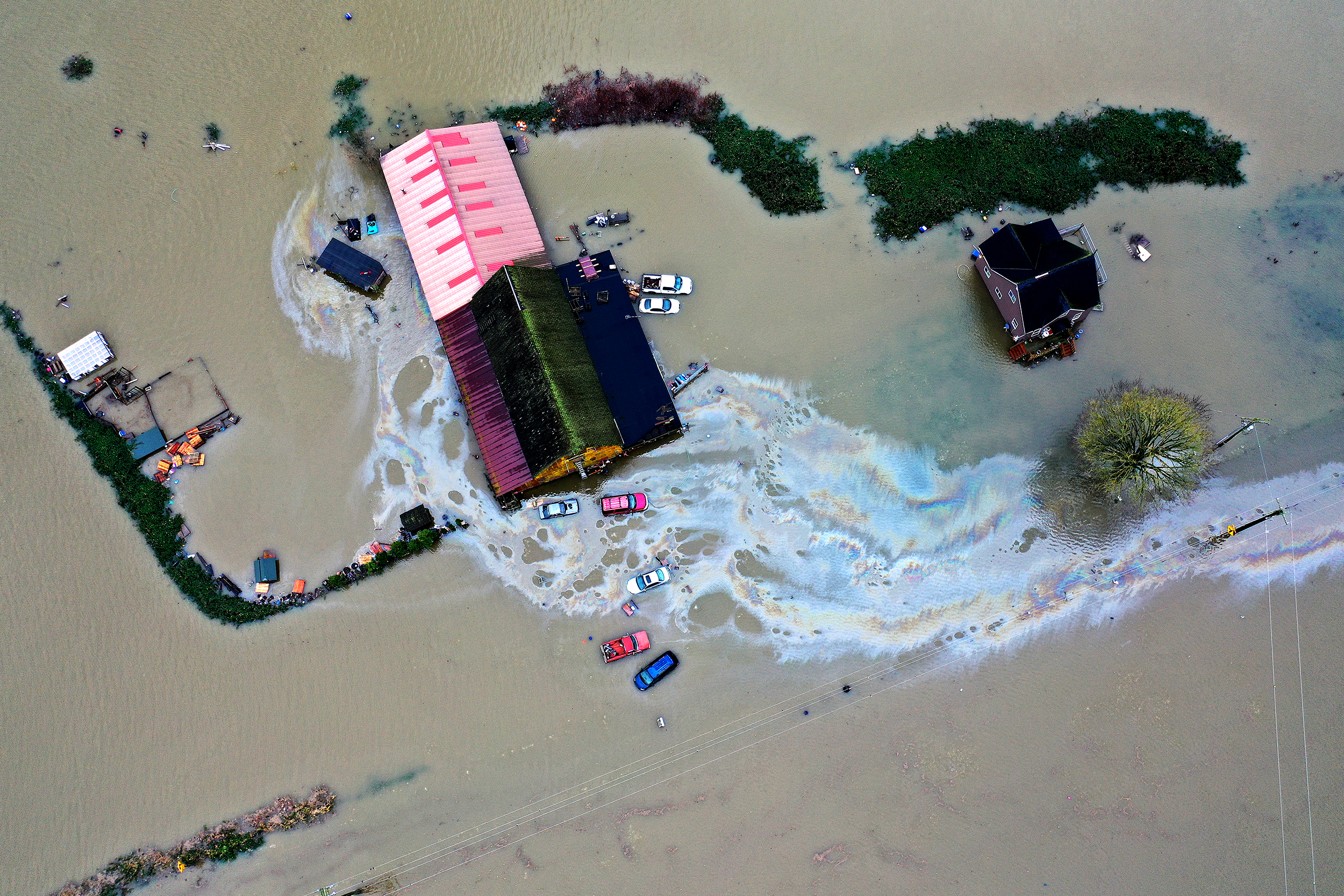 caption: Homes are shown surrounded by floodwater following consecutive atmospheric rivers on Thursday, December 11, 2025, near Mount Vernon.
