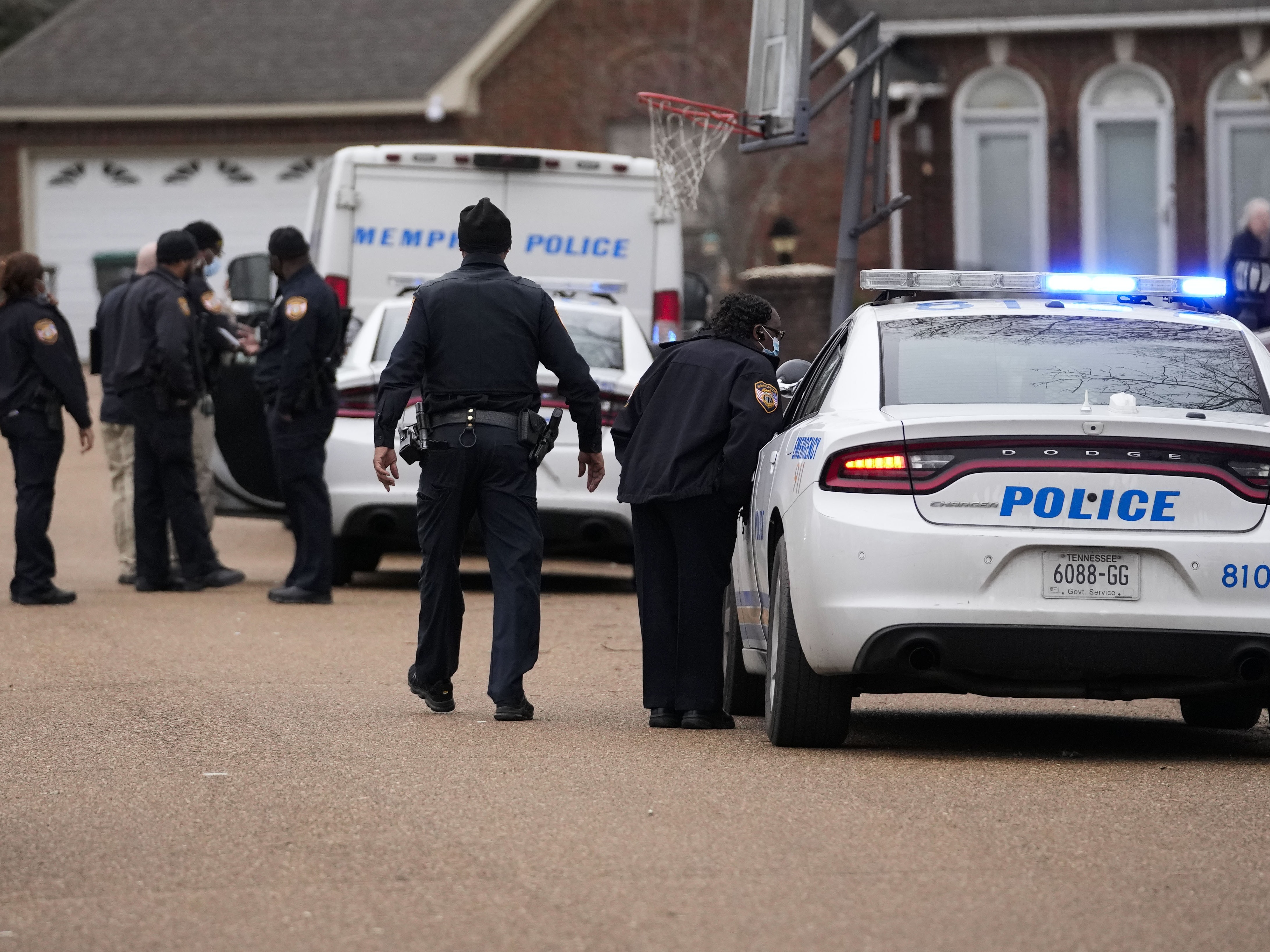 caption: Memphis police officers work a crime scene in 2023. A new report says that "Memphis police officers regularly violate the rights of the people they are sworn to serve."