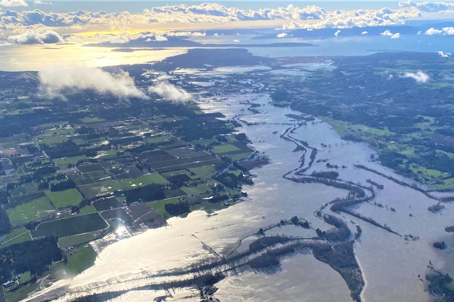 caption: The flooded Nooksack River in Whatcom County on Nov. 16, 2021 with the San Juan Islands in the background