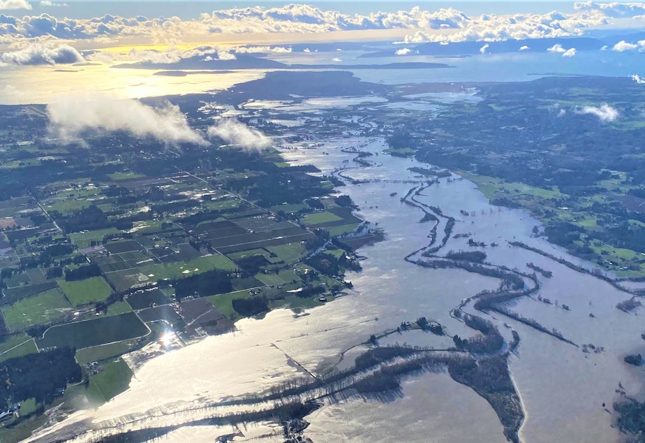 caption: The flooded Nooksack River in Whatcom County on Nov. 16, with the San Juan Islands in the background