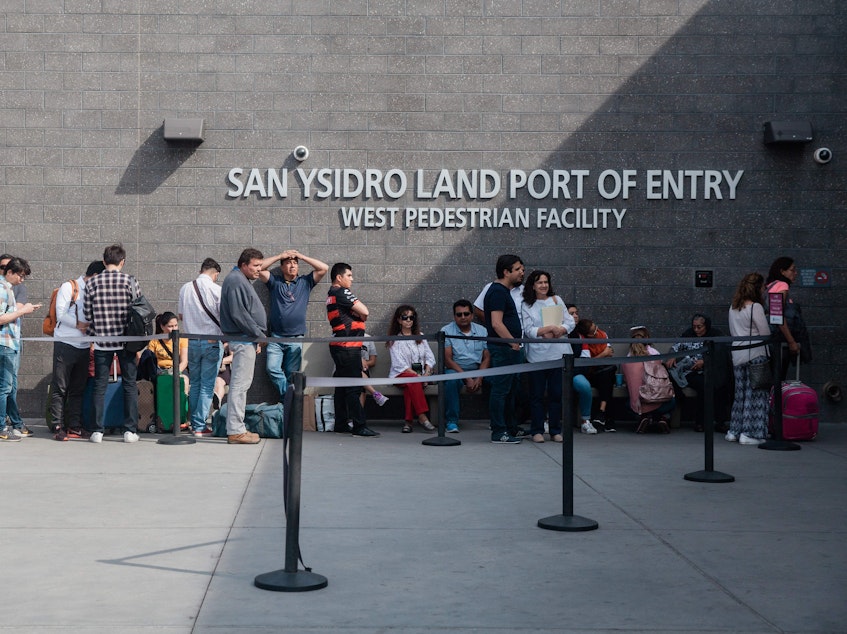 caption: People wait in line outside the San Ysidro Port of Entry, between Tijuana, Mexico, and San Diego, Calif., in October.