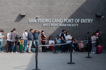 caption: People wait in line outside the San Ysidro Port of Entry, between Tijuana, Mexico, and San Diego, Calif., in October.