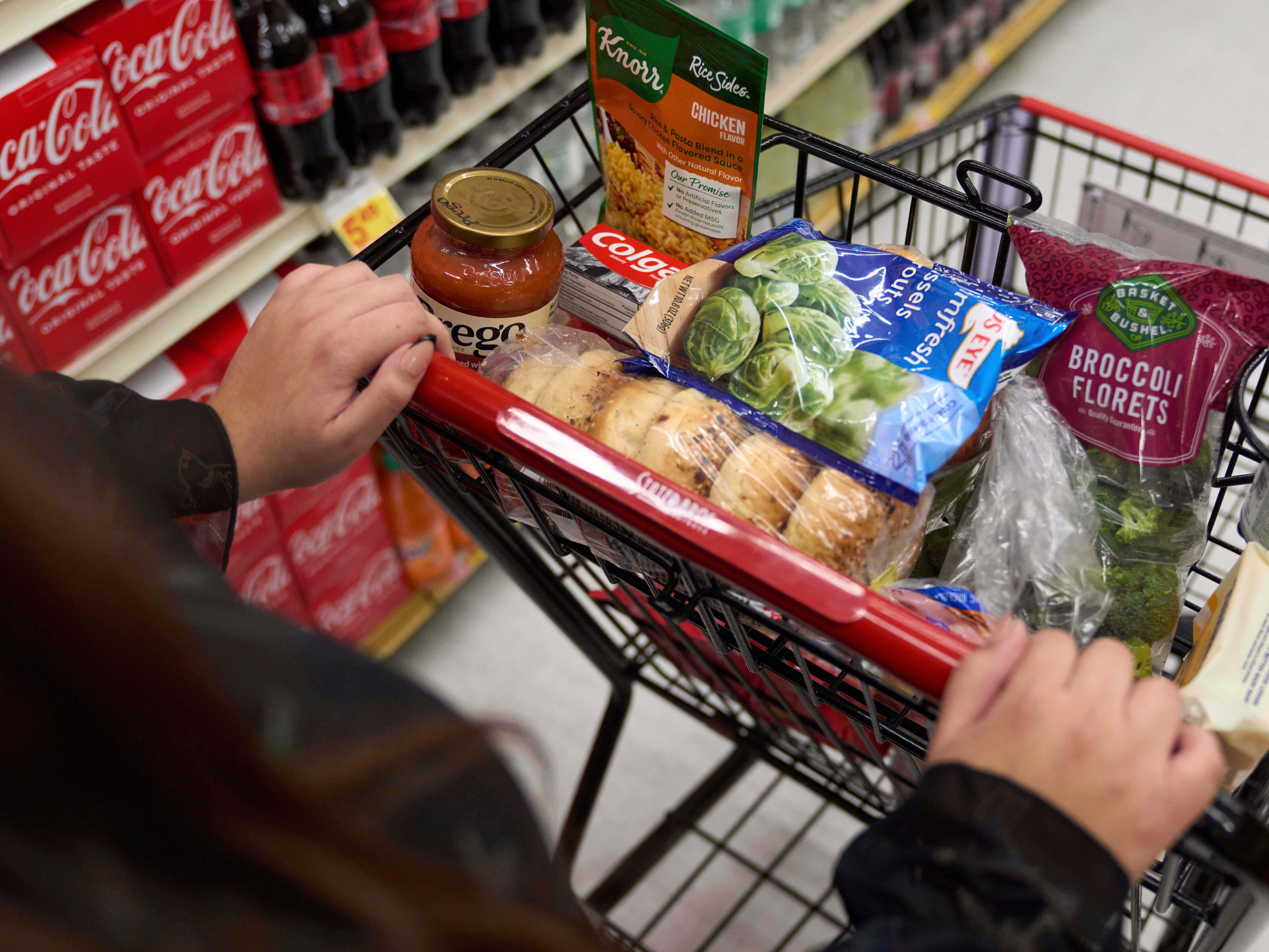 caption: A SNAP benefits shopper pushes a cart through a supermarket in Bellflower, Calif., Feb. 13, 2023.