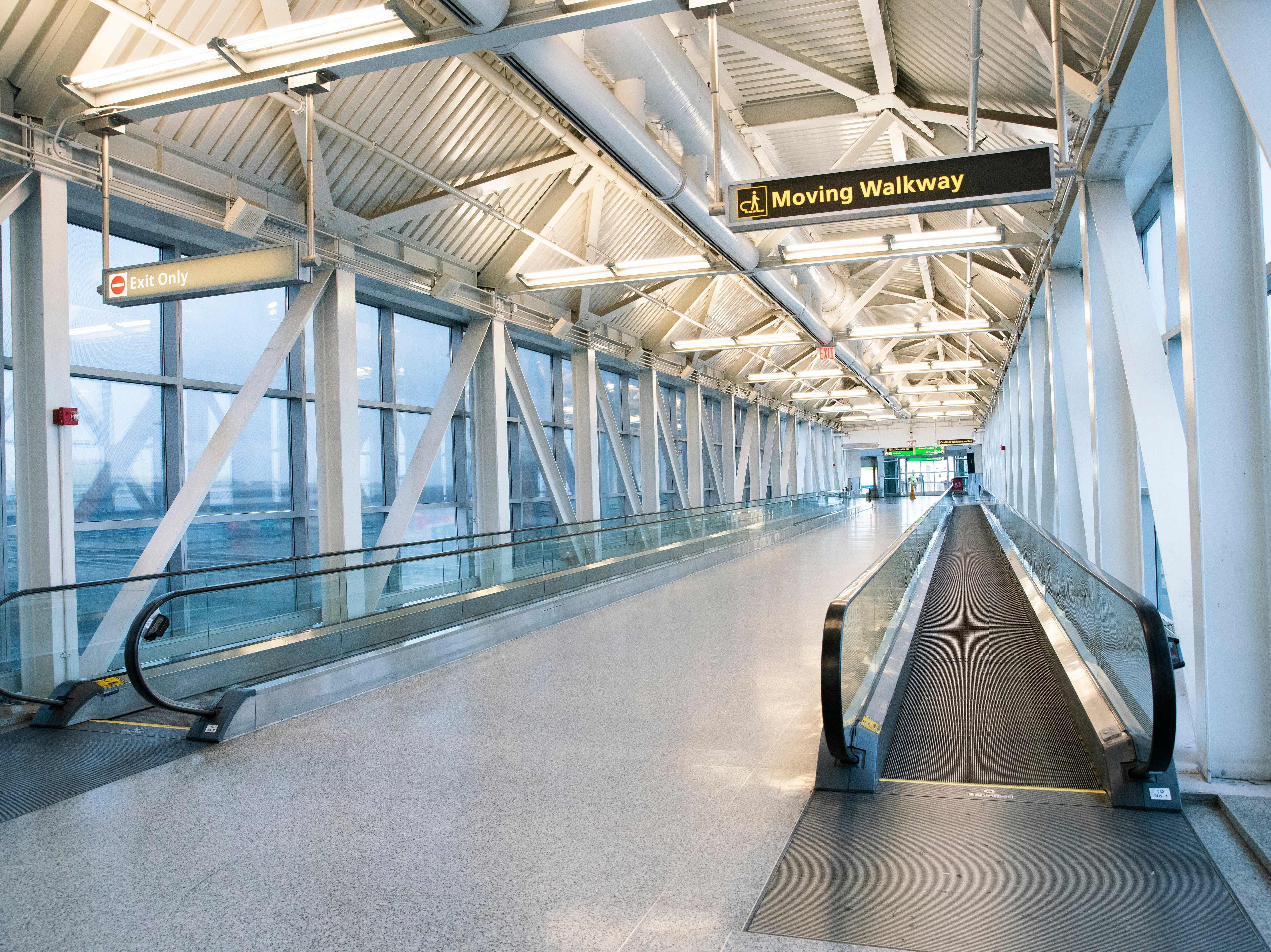 caption: An empty corridor at John F. Kennedy International Airport in New York last month. Social distancing to slow the spread of the coronavirus leaves little demand for flights.
