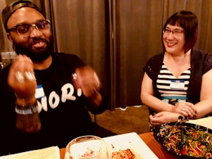 caption: Club members Timothy Bardlavens and Ginger Chien talk at KUOW's first LGBTQ-themed Curiosity Club dinner on June 7, 2019 at The Cloud Room in Seattle. 