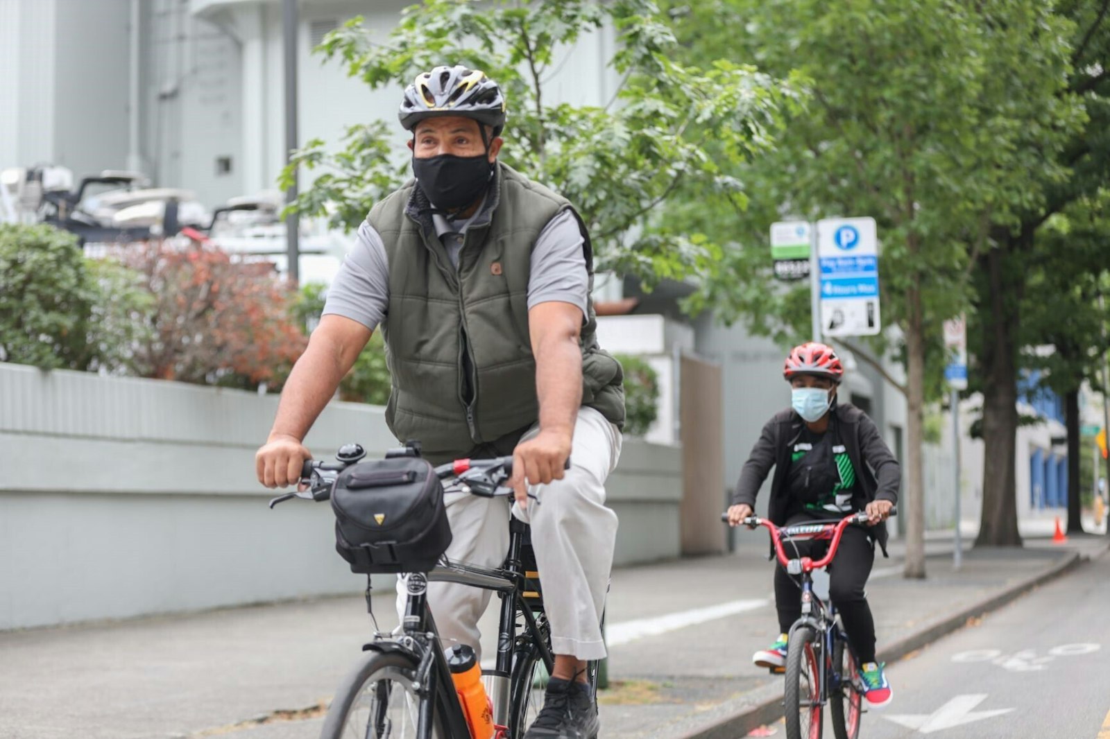 Bicyclists wearing helmets biking down a city street