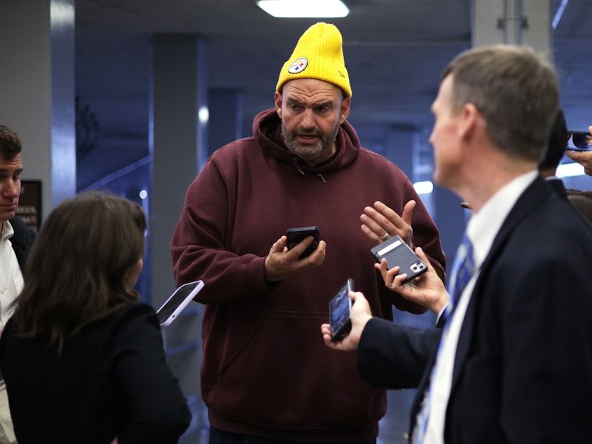 caption: Sen. John Fetterman, D-Penn., paid the recently expelled Rep. George Santos, R-N.Y., to record a video message aimed at Sen. Bob Menendez, D-N.J. Like Santos, Menendez is under a federal indictment.