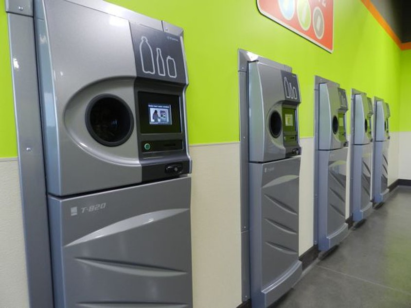 caption: A row of sparkling clean reverse vending machines greet customers at the grand opening of the Medford BottleDrop center.CREDIT: JES BURNS/EARTHFIX