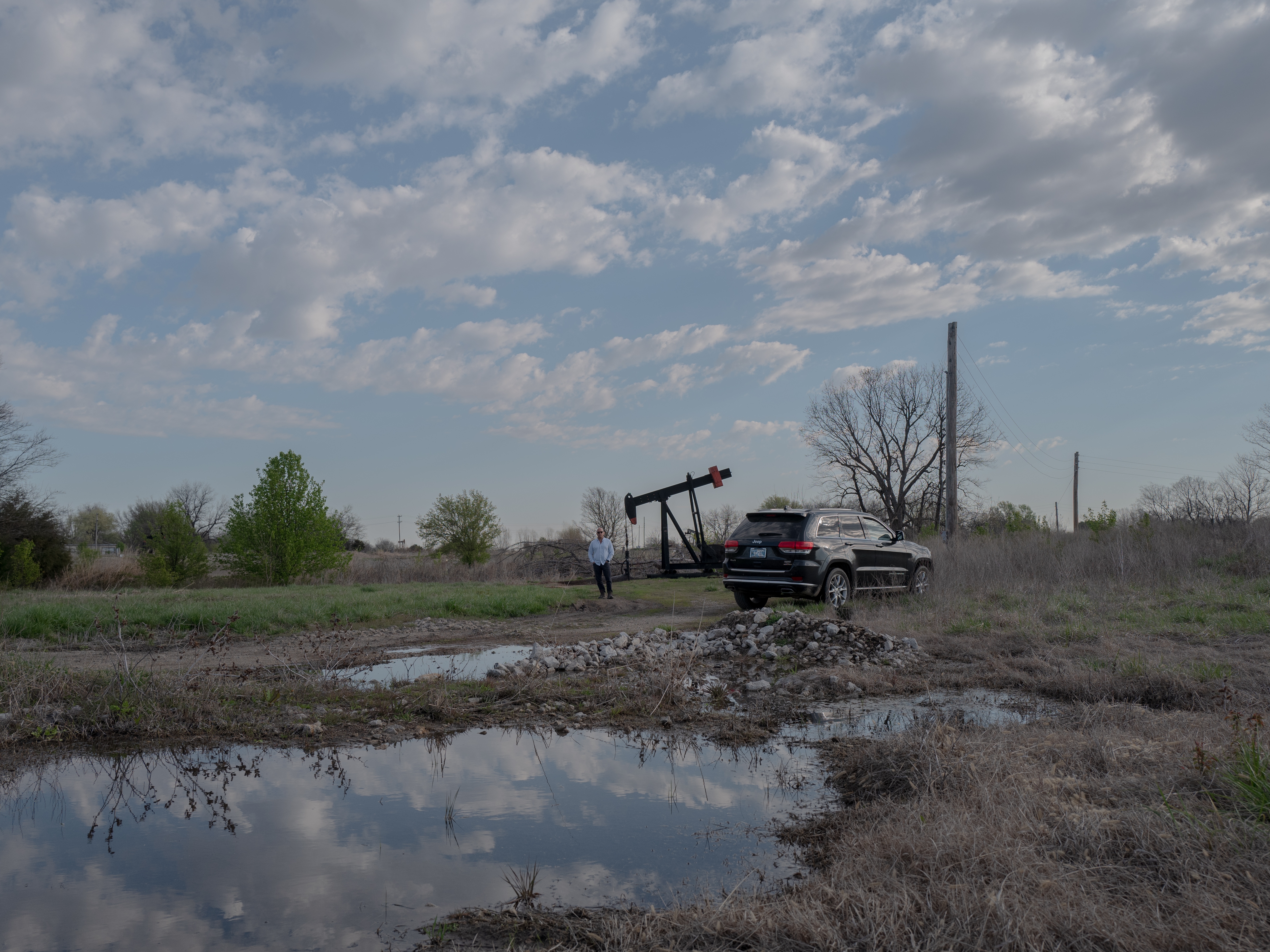 caption: Scott Rabinowitz, president of Grand Resources, stands near a pump jack in Sperry, Okla., on March 20, 2024.