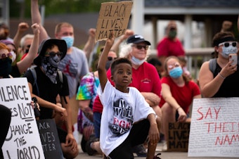 caption: Amari Jackson, 7, holds up a Black Lives Matter sign during a peaceful protest against police violence in Bridgeport, Pa., on June 3.