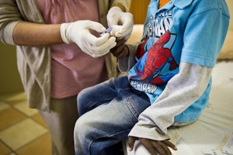 caption: A staffer at the Right to Care AIDS clinic in Johannesburg administers an HIV test on a young boy. South Africa is one of the countries that receives funds from the U.S. President's Emergency Plan for AIDS Relief (PEPFAR).