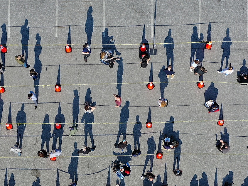 caption: People line up for COVID-19 vaccinations last month in Hagerstown, Md. Each person vaccinated helps end the pandemic, epidemiologists say, and helps lower the rate of hospitalization and death from COVID-19.
